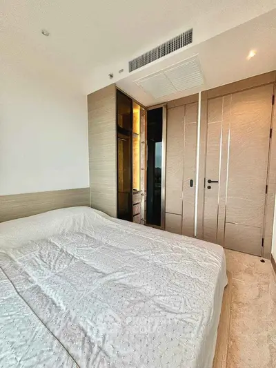 Modern bedroom with sleek design and neutral tones, featuring built-in wardrobe and cozy ambiance.
