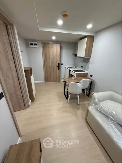 Modern compact living space with wooden flooring and minimalist furniture