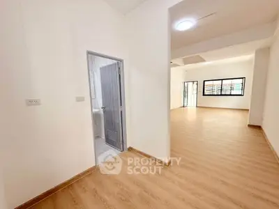 Spacious open-plan living area with wooden flooring and ample natural light.