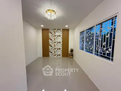 Elegant modern living room with stylish chandelier and large window, featuring marble accent wall and glossy tile flooring.