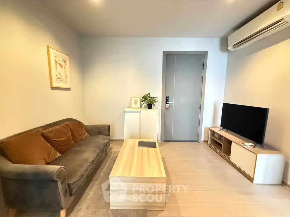 Modern living room with cozy sofa, sleek TV setup, and stylish decor in a contemporary apartment.