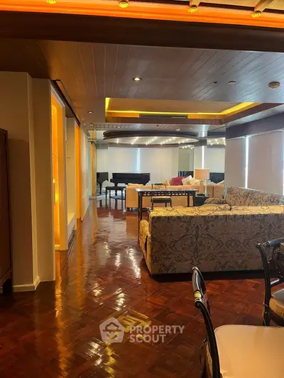 Luxurious living room with elegant furniture and grand piano, featuring polished wooden floors and ambient lighting.