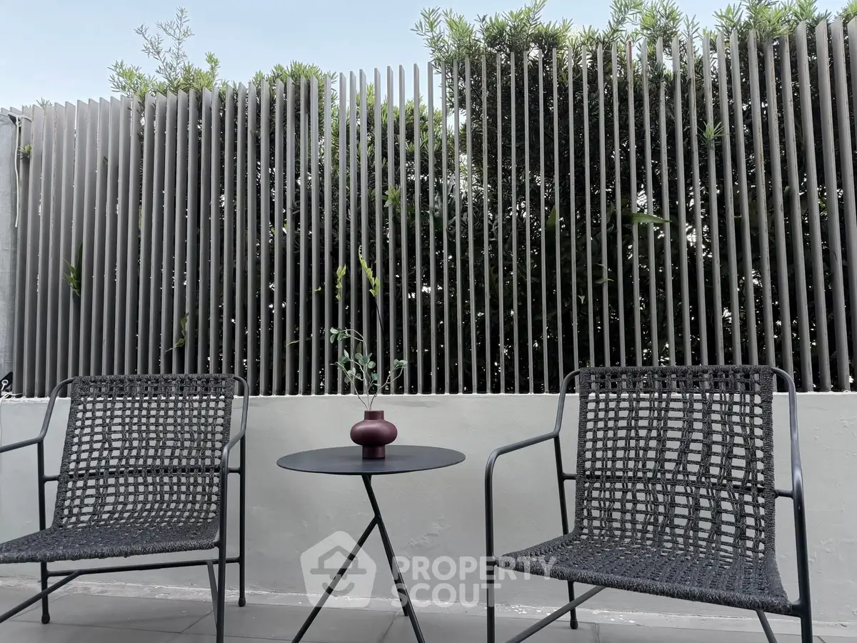 Stylish outdoor patio with modern chairs and table, perfect for relaxation.