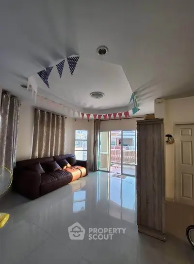 Spacious living room with large windows and festive decor, perfect for family gatherings.