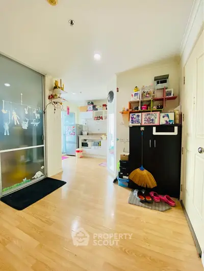 Charming entryway leading to a cozy kitchen with wooden flooring and modern decor.