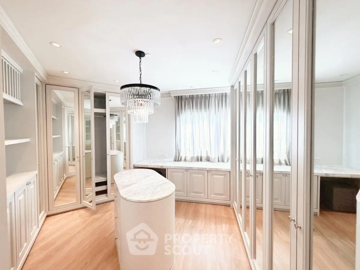 Luxurious walk-in closet with elegant chandelier and ample storage space