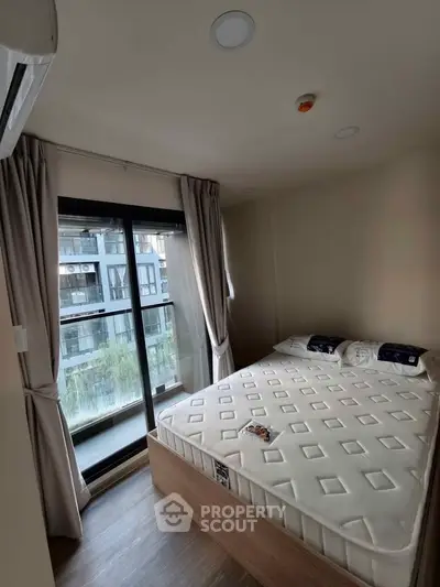 Cozy bedroom with large window and modern decor in urban apartment