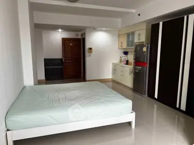 Spacious studio apartment with modern kitchen and ample storage space.