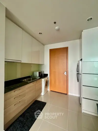 Modern kitchen with sleek cabinetry and integrated appliances in a stylish apartment.
