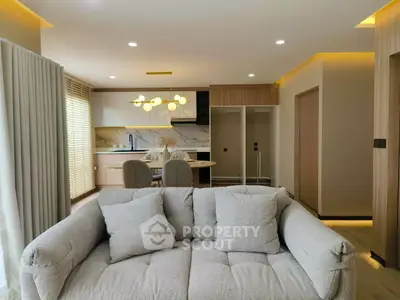 Modern open-plan living room with stylish kitchen and cozy sofa, perfect for contemporary living.