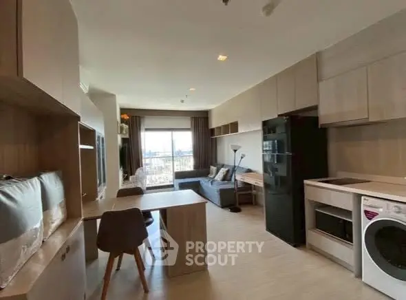 Modern open-plan living room with kitchen, featuring sleek furniture and appliances.