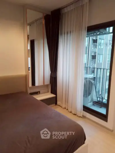 Modern bedroom with large window and balcony view in urban apartment