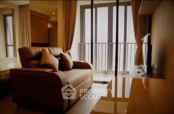 Cozy living room with modern sofa and large windows offering natural light.