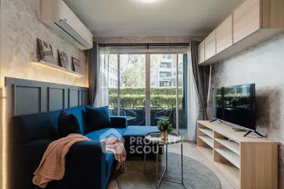 Modern living room with blue sofa, TV, and balcony view in stylish apartment.