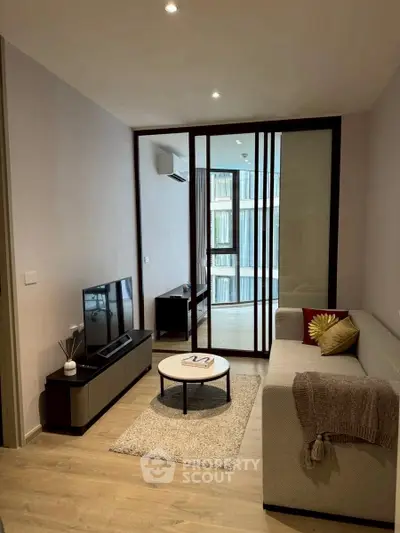 Modern living room with sleek furniture and large windows in a stylish apartment.