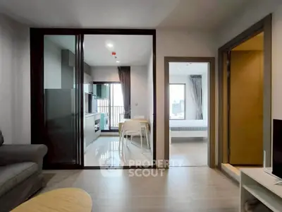 Modern apartment interior with open kitchen and dining area, featuring sleek design and natural light.