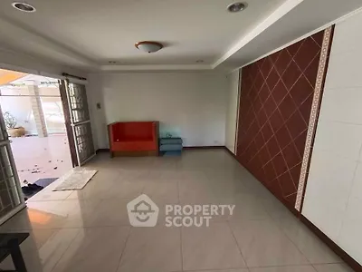 Spacious living room with tiled floor and unique wall design, perfect for customization.