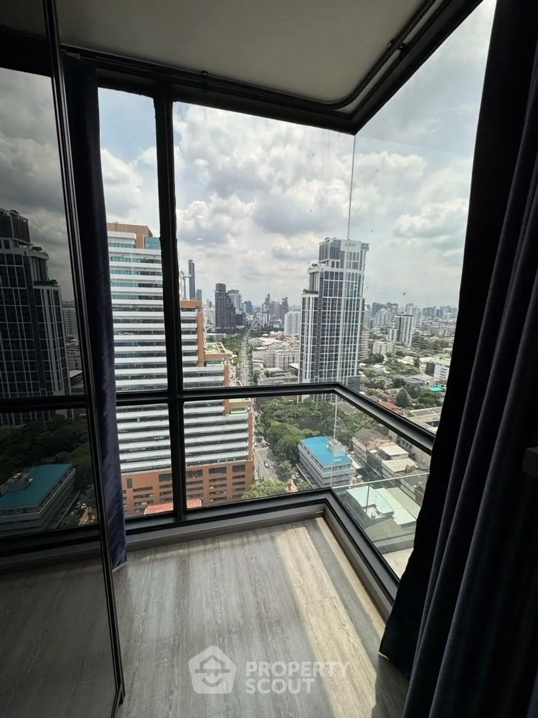 Stunning cityscape view from a high-rise corner unit with floor-to-ceiling windows.