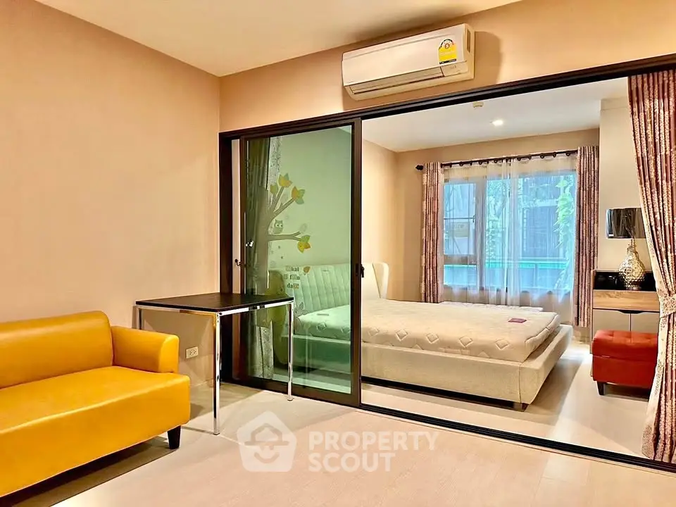 Modern apartment with glass partition, cozy living area, and stylish bedroom.