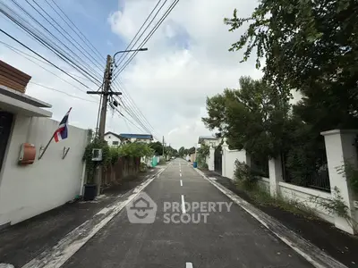 Charming residential street view with lush greenery and modern homes, perfect for serene living.