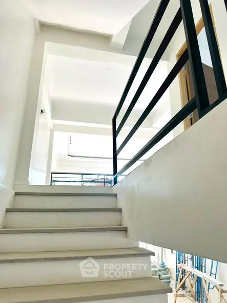 Modern staircase with sleek railing in a bright, airy building interior