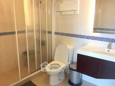 Modern bathroom with glass shower and sleek vanity in a contemporary home.