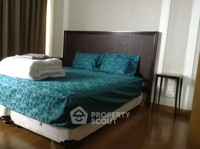 Cozy bedroom with elegant bedding and wooden flooring in modern apartment.