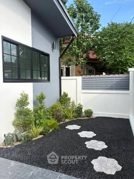 Charming modern home exterior with landscaped garden and stepping stones