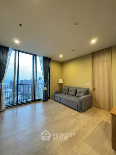 Spacious living room with large windows offering stunning city views.
