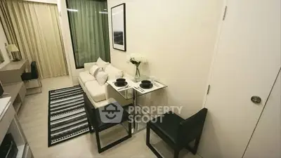 Modern living room with cozy dining area and stylish decor in a compact apartment.