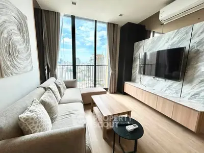 Modern living room with floor-to-ceiling windows and city view, featuring stylish decor and comfortable seating.