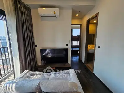 Modern living room with balcony view, featuring sleek furniture and air conditioning, perfect for urban living.