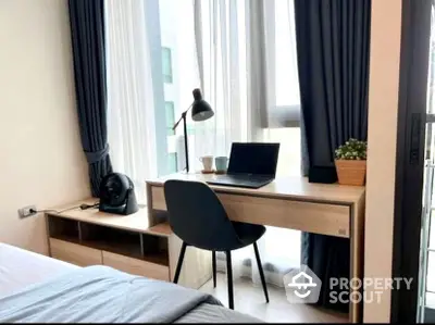 Modern bedroom with a dedicated workspace featuring a sleek desk, comfortable chair, and ample natural light from the large window, perfect for professionals.