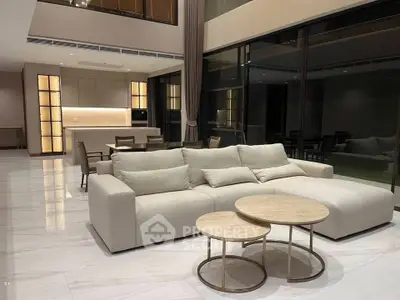 Luxurious modern living room with high ceilings and elegant furniture in a spacious open layout.