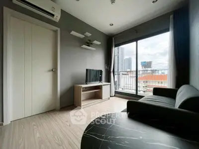 Modern living room with city view, featuring sleek furniture and large windows for natural light.