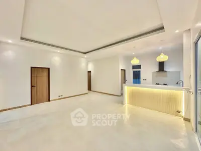 Spacious modern living room with open kitchen and elegant lighting