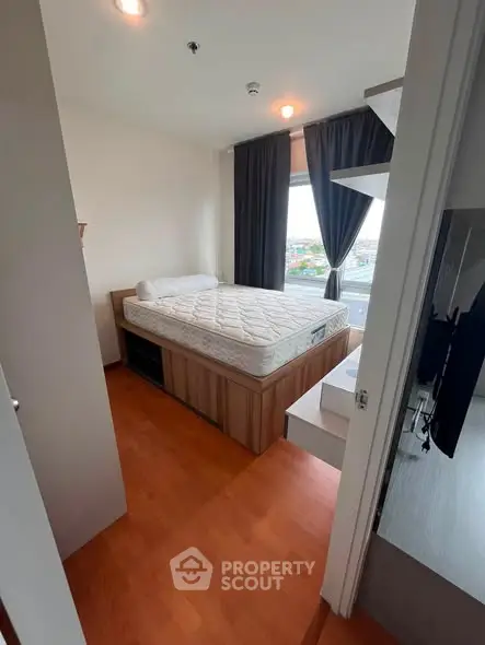 Cozy bedroom with large window and wooden flooring, featuring a comfortable bed and modern decor.