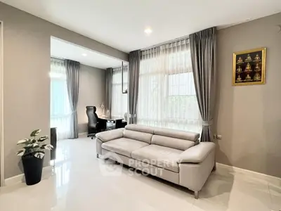 Modern living room with sleek sofa and study area, bright natural light