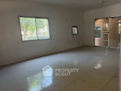 Spacious empty room with large windows and glossy tiled floor, ideal for customization.