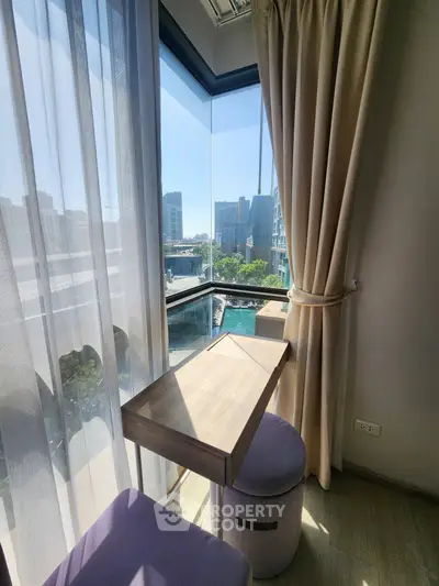 Chic urban balcony with stunning city view and cozy seating area.