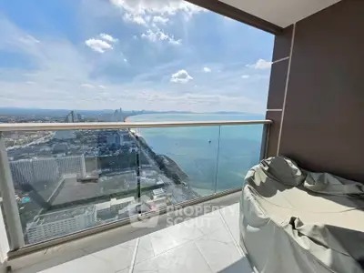 Stunning high-rise balcony with panoramic ocean view and modern seating area.