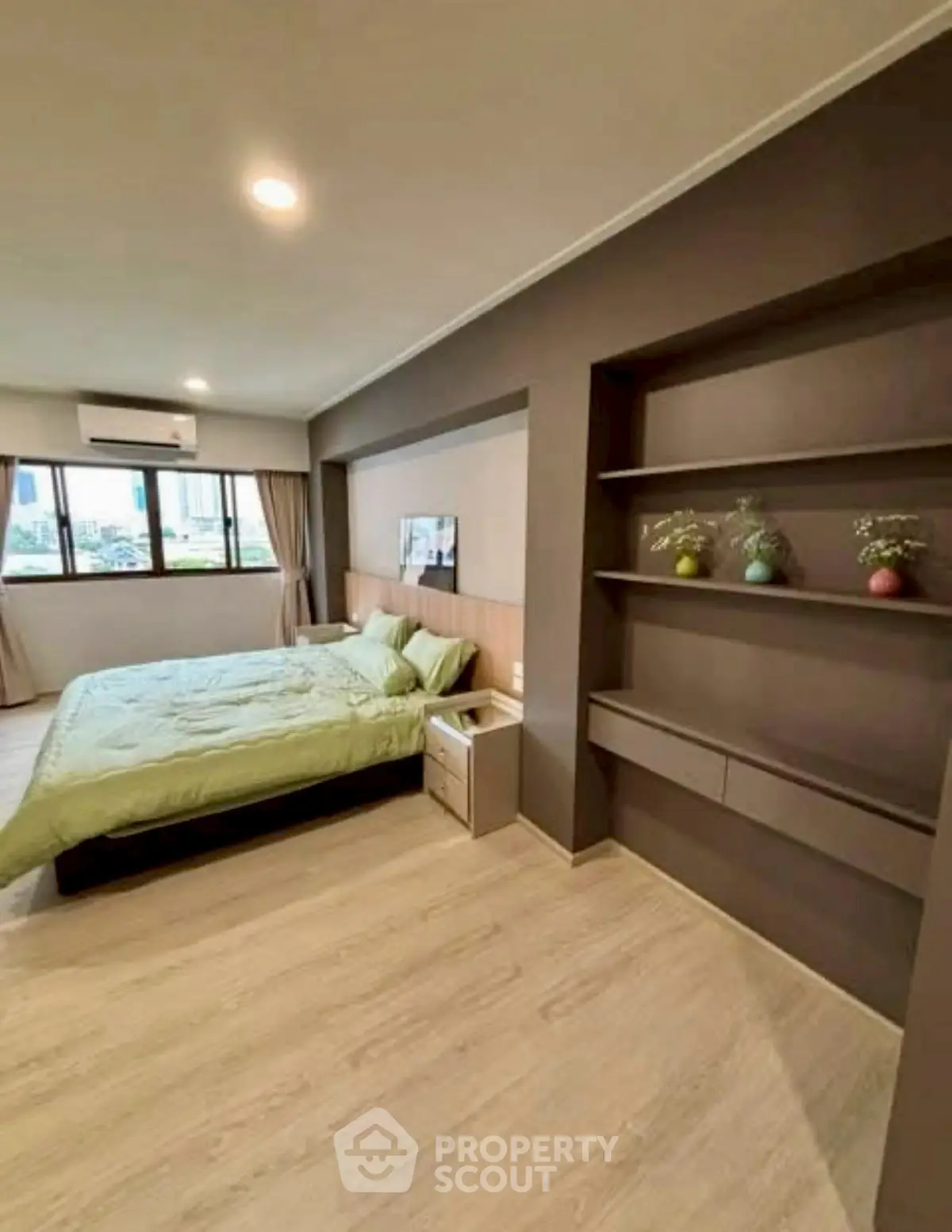 Spacious modern bedroom with built-in shelves and large window view.