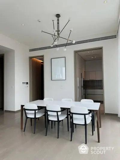 Modern dining area with sleek furniture and contemporary lighting in a stylish apartment.