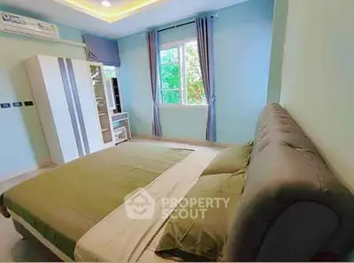 Spacious bedroom with large window and modern decor