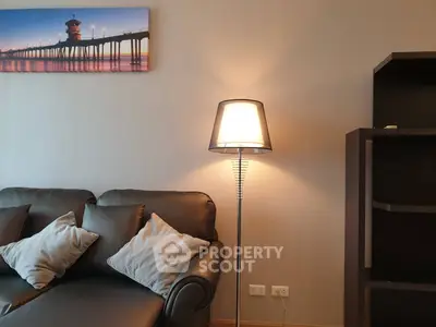 Cozy living room with stylish sofa and modern floor lamp, perfect for relaxation.