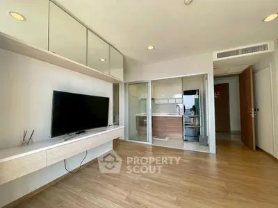 Modern living room with sleek TV setup and open kitchen design