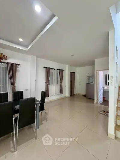 Spacious modern dining area with sleek black chairs and elegant curtains, perfect for family gatherings.