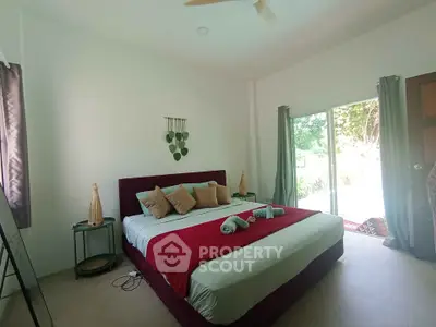 Spacious bedroom with large bed and natural light from sliding glass doors.