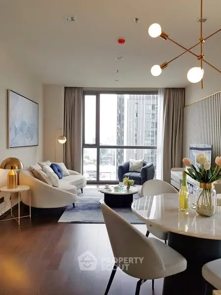 Modern living room with elegant decor and large windows offering city views.