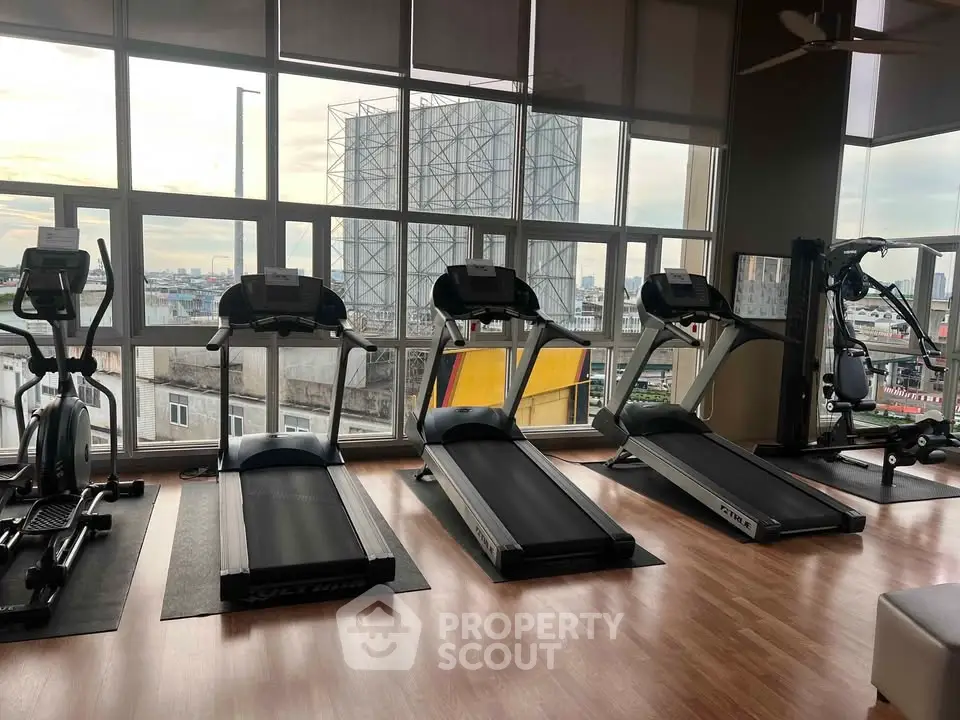 Modern gym with city view and state-of-the-art equipment for fitness enthusiasts.
